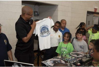 Todd Taylor presenting a Cops and Kids DJ Battle t-shirt